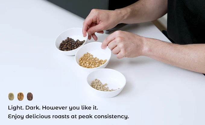 A hand comparing multiple light and dark coffee roast samples