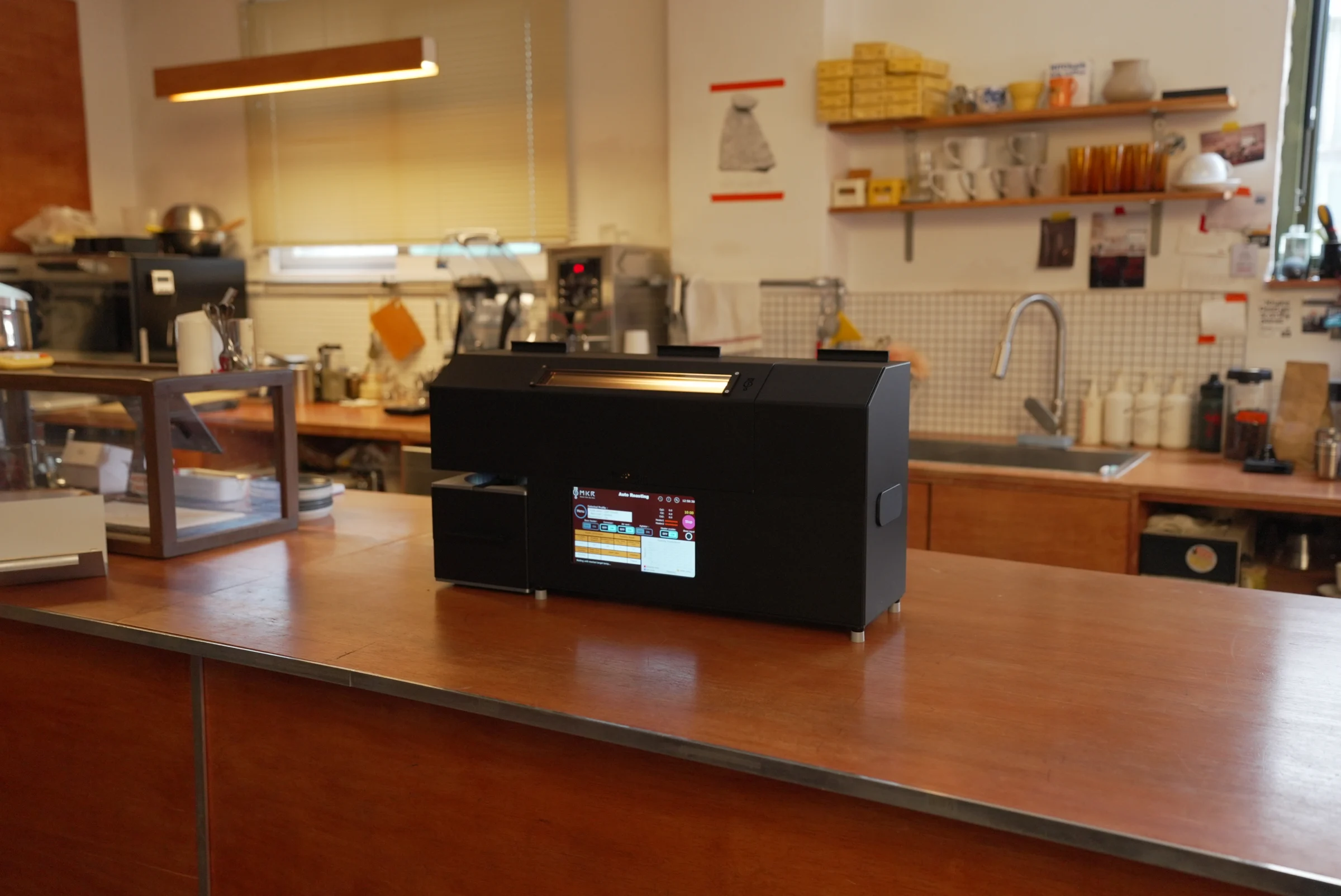 ROASTREAM coffee roaster on a wooden counter in a working coffee studio
